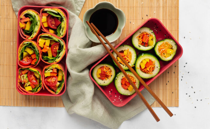 Lunchbox met regenboogwraps en komkommersushi